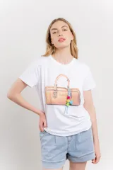 Remera blanca de algodón con estampado de un bolso con llavero colorido.