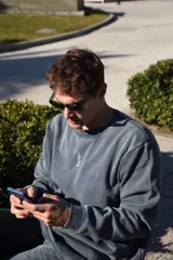 Buzo azul con efecto lavado, cuello redondo y logo bordado en el pecho.