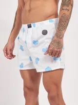 Bóxer de algodón blanco con estampado de flores pequeñas color celeste, con cintura elástica y logo de la marca en el centro.