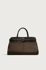 Bolso de mano estructurado en color marrón, confeccionado en una combinación de materiales que incluye gamuza en el cuerpo principal y cuero en la parte superior y asas. Presenta un detalle de cinturón decorativo con hebilla metálica plateada en la parte frontal, doble asa de mano y cierre principal con imán.