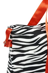 Bolso tipo tote con estampado de cebra en blanco y negro, con doble compartimento y asas de color naranja.