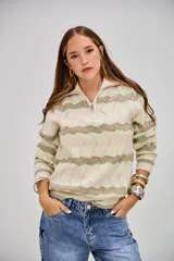 Sweater de punto con cuello alto y cierre frontal, de manga larga. Presenta un patrón de ondas en tonos beige, verde claro y blanco.