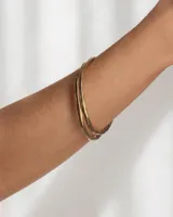 Pulsera rígida de bronce y alpaca, adaptable a muñecas de 13 a 15 cm.