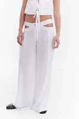 Pantalón sastrero de lino italiano color beige, de corte recto y holgado, con aberturas laterales en la cintura y pinzas.