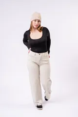 Pantalón wide leg color crudo de tiro medio, con diseño de cinco bolsillos y cierre frontal con botón y cremallera.