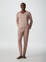 Pijama de dos piezas color rosa, compuesto por una remera de mangas largas con cuello en V y un pantalón largo de corte recto.