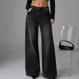 Pantalón jean de corte wide leg en color negro con efecto acid wash y acabado desgastado. Cuenta con tiro medio, bolsillos delanteros y traseros, y cierre frontal de botón y cremallera.