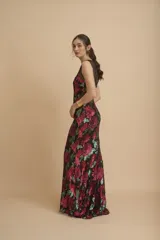 Vestido largo negro íntegramente bordado con lentejuelas en tonos fucsia y verde, con diseño floral, escote redondo y transparencias en la parte superior.