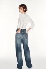 Jeans de tiro alto y estilo wide leg, con diseño de cinco bolsillos, lavado oscuro con efecto desgastado, pierna ancha larga y bajo sin costuras.