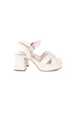 Sandalias de cuero color off white con tiras cruzadas en la parte delantera, plataforma y taco ancho cuadrado. Cuenta con tira ajustable al tobillo con hebilla metálica dorada.