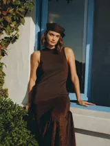 Vestido largo marrón de tejido con caída fluida, diseño sin mangas, cuello redondo y silueta entallada en la parte superior que se amplía suavemente hacia el ruedo.