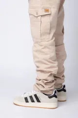 Pantalón cargo color beige, con bolsillos laterales tipo cargo con solapa y cierre de botón, corte recto y ajuste cómodo.