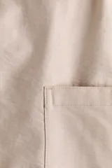 Pantalón cargo de color beige, con perneras estilo globo, cintura elástica y bolsillos laterales de parche.