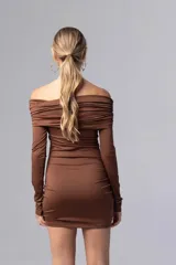 Vestido corto color chocolate con escote off-shoulder y mangas largas. Presenta frunces verticales en el frente.