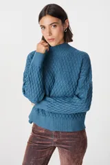 Sweater color crudo con cuello alto y diseño de tejido panal.