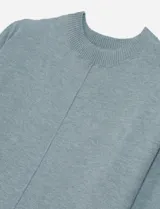 Vestido tipo sweater color blanco, de corte recto y largo hasta la rodilla, con cuello redondo y mangas largas.