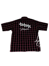 Camisa negra a cuadros rojos con estampado de estrellas y logo de la marca en la espalda.