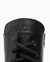 Borcego negro de cuero con cordones, caña media y suela track.