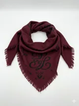 Bandana de lana color bordó con estampado gráfico en negro y bordes desflecados.