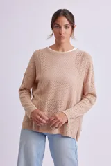 Buzo de punto fantasía color beige con diseño calado, escote redondo y mangas largas.
