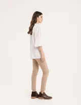 Pantalón chupín color beige de gabardina elastizada con tajitos frontales en el ruedo, pierna recta justa y bolsillos laterales.