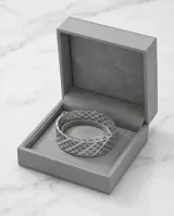 Esclava rígida de acero con diseño calado de círculos entrelazados y detalles de circonias engastadas.
