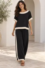 Blusa de manga corta color beige, con cuello redondo, dobladillo inferior y puños en color negro.
