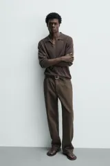 Pantalón cargo straight fit de algodón color negro con efecto lavado, bolsillos laterales en las piernas y cierre frontal con cremallera y botón.