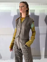 Chaleco de lana texturizada color marrón con alforzas en los laterales, cuello alto y pequeñas mangas.