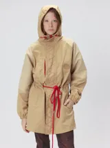 Campera tipo piloto con capucha, cierre frontal con botones y detalle de costuras en zigzag. Presenta cordones ajustables en la cintura y capucha, puños elásticos y logo bordado en el pecho.