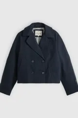 Campera tipo trench corta de corte amplio, color azul marino, con diseño de doble botonadura y cuello con solapas.