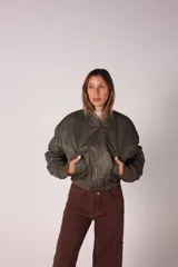 Campera bomber verde militar con cuello de corderito desmontable, cierre frontal y puños y ruedo elastizados.