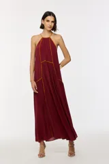 Vestido largo color bordó con escote halter, diseño holgado y detalles de ribetes en contraste.