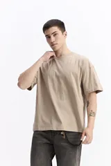 Remera de manga corta, color verde oscuro con efecto gastado o lavado, de corte holgado (boxy) y escote redondo.