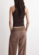 Top de punto fino color marrón, con diseño entallado, cuello redondo, tirantes anchos y sin mangas.