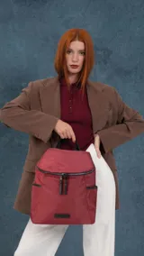 Mochila urbana de diseño compacto, color bordó, con cierre principal doble, bolsillo frontal con cierre y bolsillos laterales. Cuenta con manija superior y correas ajustables.