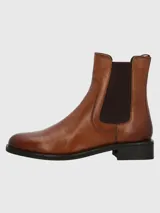 Bota tipo chelsea de cuero color marrón, con paneles elásticos laterales en color marrón oscuro, suela de goma negra y taco cuadrado bajo.