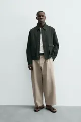 Cazadora relaxed fit color verde oscuro, confeccionada en tejido de algodón. Cuenta con cuello solapa, manga larga con puño abotonado, bolsillos plastrón con solapa en la cadera y cierre frontal de botonadura.