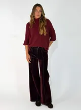 Pantalon de corte recto y tiro medio, confeccionado en pana color bordó, con costuras verticales en contraste y bolsillos laterales.