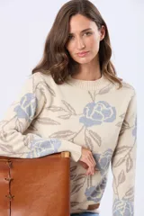 Buzo tejido en jacquard con estampado floral en tonos azul y marrón sobre base color crema. Presenta cuello redondo y puños acanalados.