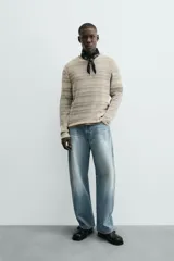 Camiseta de manga larga con cuello redondo y ajuste relajado, confeccionada en tejido de punto con estructura abierta y patrón de rayas horizontales.