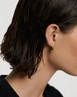 Aros colgantes dorados con forma de gota.