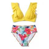 Bikini de dos piezas compuesto por un top amarillo con volados en los hombros y una bombacha de tiro alto con estampado tropical de flores y hojas.