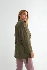 Chaqueta de gamuza sintética color bordó, con cuello solapa, cierre frontal de botones y cinturón ajustable del mismo material. Posee bolsillos frontales y mangas largas.