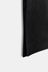 Pantalón capri negro de tiro medio y corte ajustado, confeccionado en tejido elástico con cintura elástica.