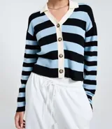 Cardigan de punto con diseño de rayas horizontales en negro y celeste. Presenta cuello polo en color crema, cierre frontal con botones y mangas largas.