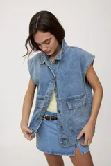 Chaleco de jean negro de calce relajado, con cuello camisero, cierre frontal con botones metálicos y bolsillos delanteros con solapa.