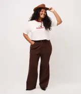 Pantalón wide leg de sarga color marrón, con cintura estructurada, cierre frontal con botón y cremallera, y bolsillos funcionales.