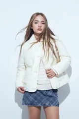 Campera acolchada de color negro con diseño capitoneado, cierre frontal con botones y cuello clásico.