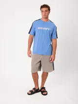 Remera negra de manga corta con diseño deportivo, parte superior de las mangas en color gris con ribete blanco y estampa frontal con la marca Rusty.